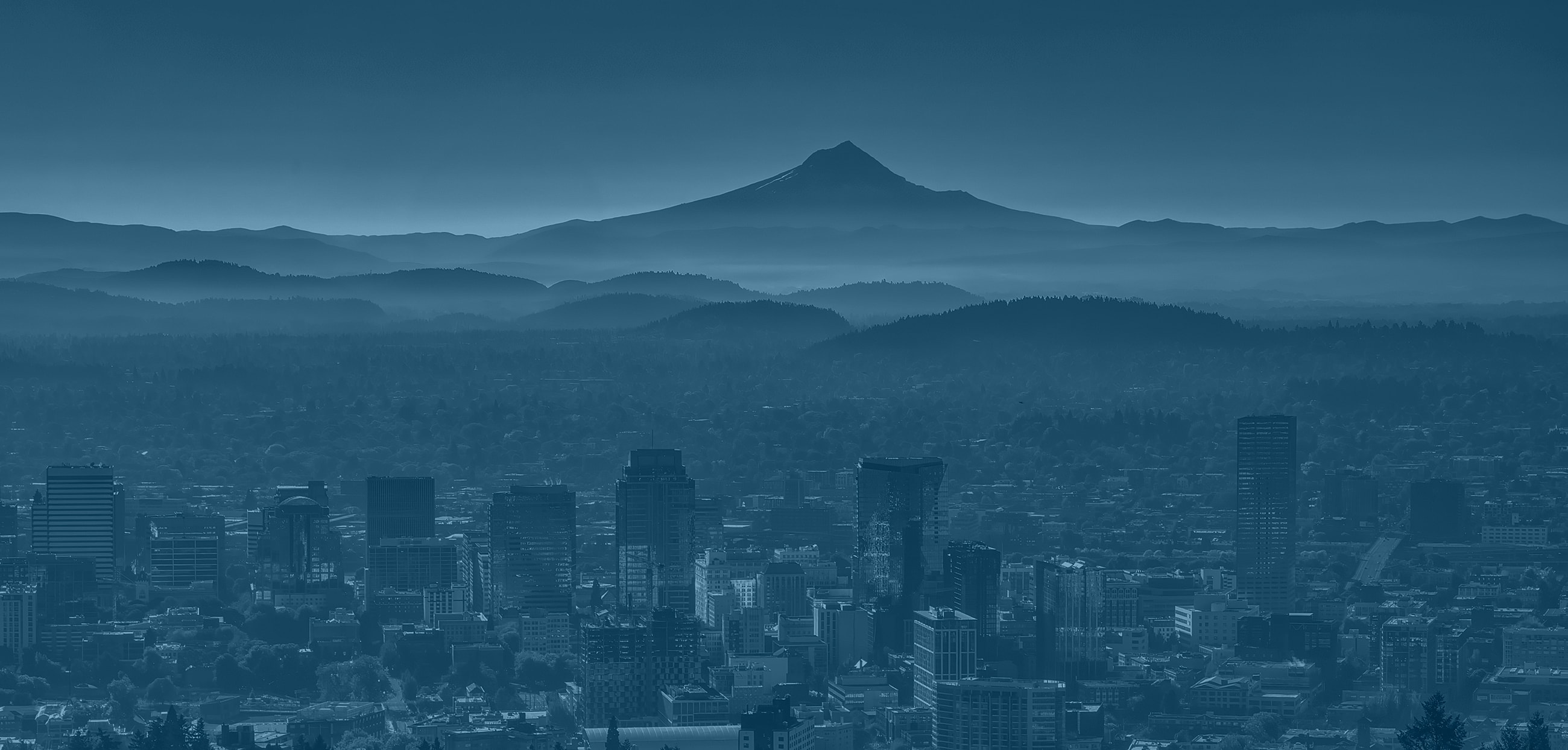City skyline with mountains in the background.