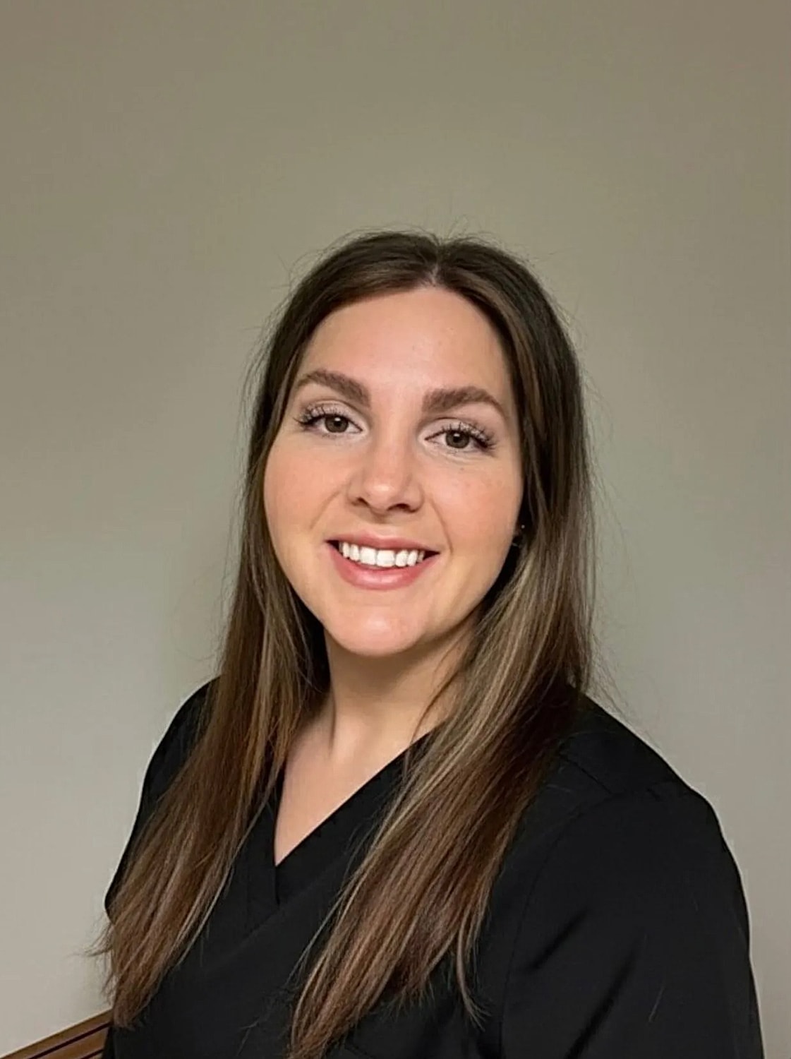 Woman in professional attire, smiling confidently.